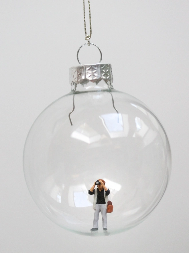 miniature photographer figure in a glass christmas bauble