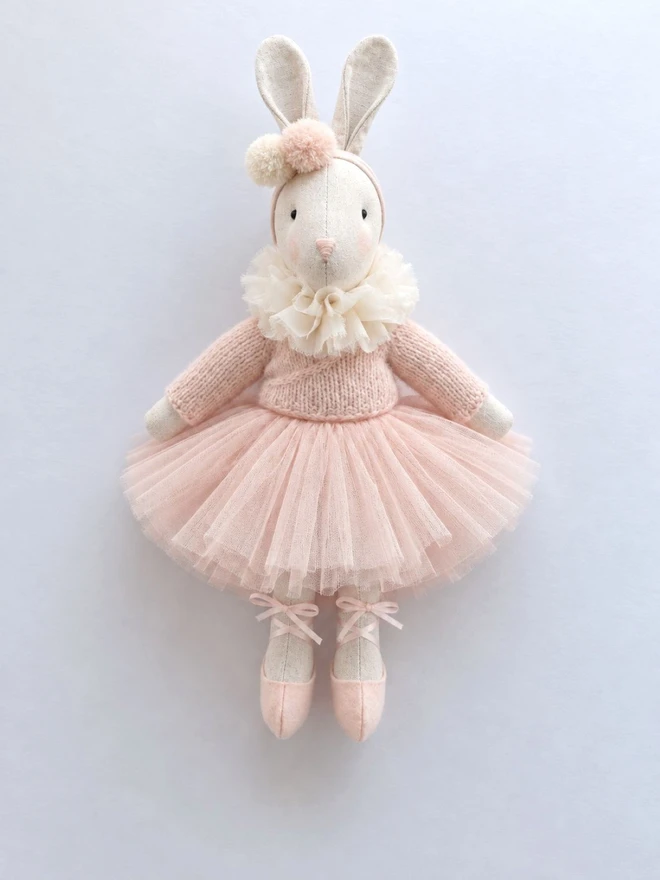 Flat lay of Verity ballerina bunny in a pale pink knitted cardigan, tulle tutu and ballet shoes.
