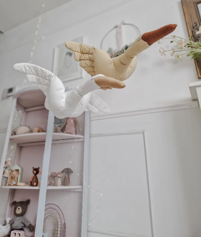 Flying Swan Hanging Decoration, a hanging beige swan decoration, suspended in a child's bedroom. 