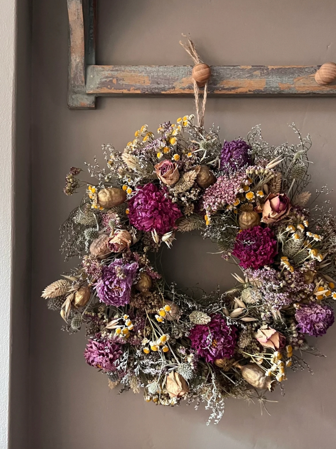 Autumnal Everlasting Wreath. A wreath made of seasonal autumnal flowers and plants, hung on a wall.