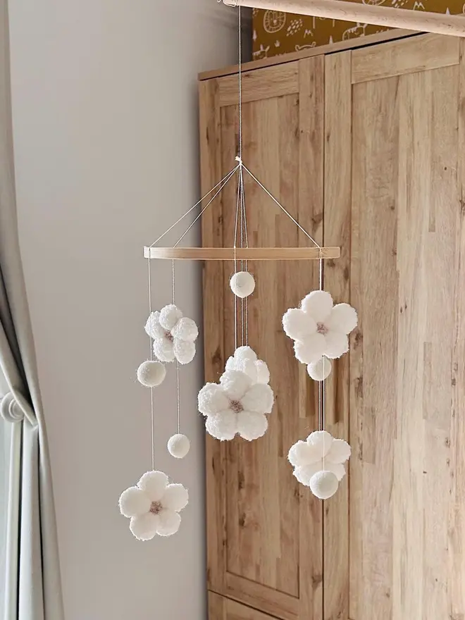 boucle flower baby mobile. a white cloth baby mobile hanging from the ceiling.