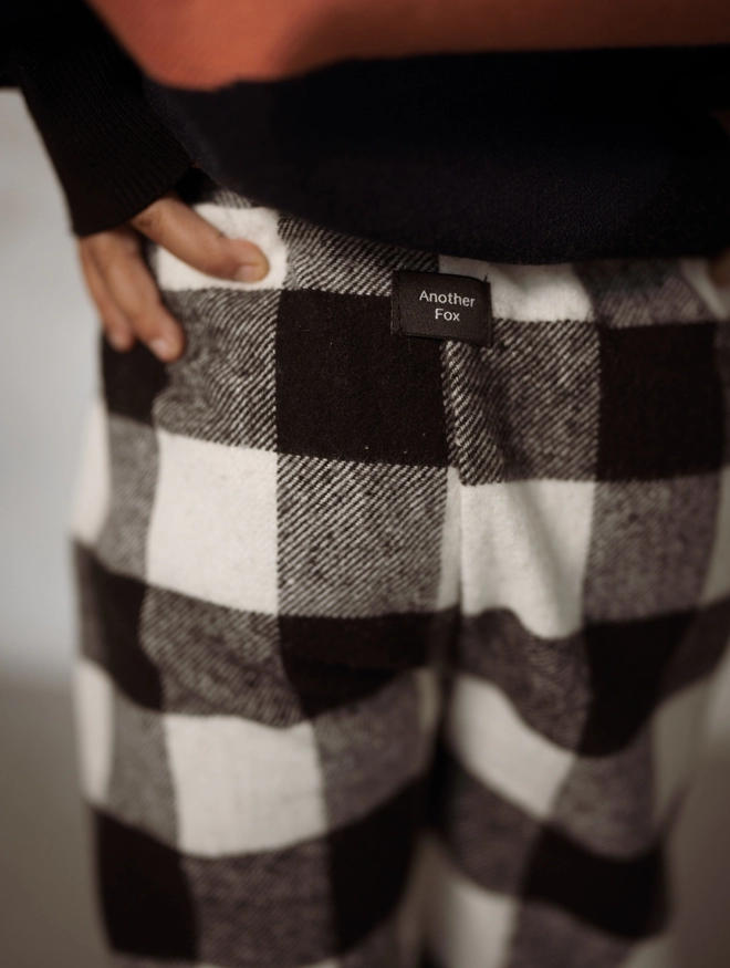 Detail of the Monochrome Flannel Check Trousers with the Another Fox logo.