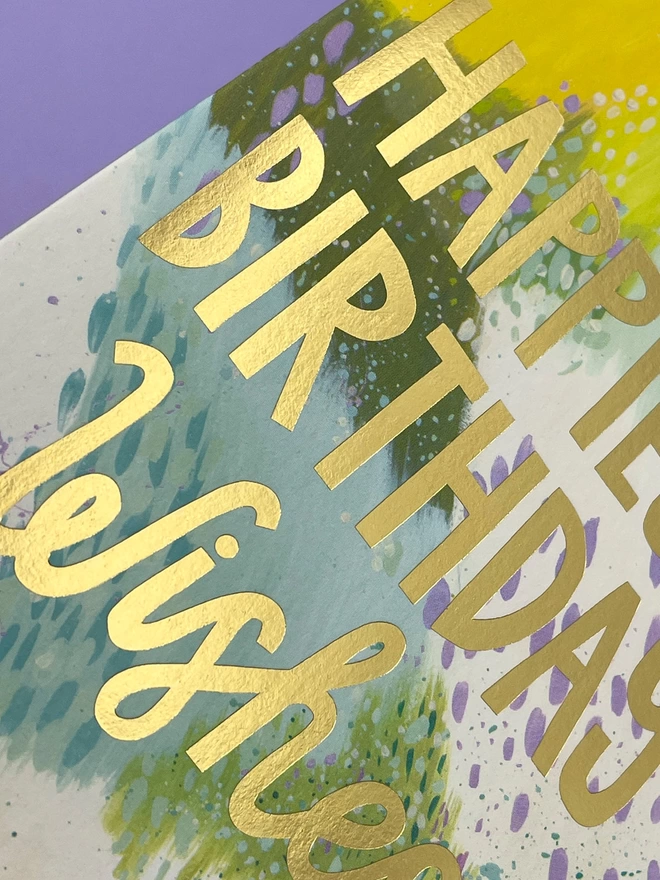 A detailed look at the abstract painterly design and gold foil finish