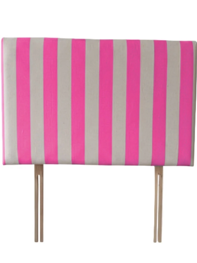 Hand Painted Upholstered Linen Headboard In Stripe Print, a neon pink striped headboard sitting against a white background. 