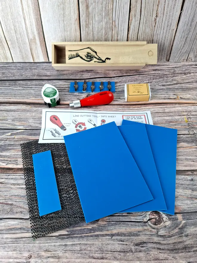 Carving kit in wooden box showing contents and pack of blue lino