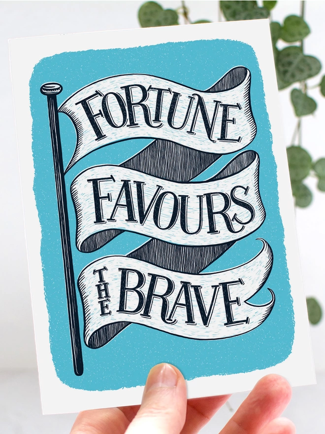 hand holding blue fortune favours the brave card