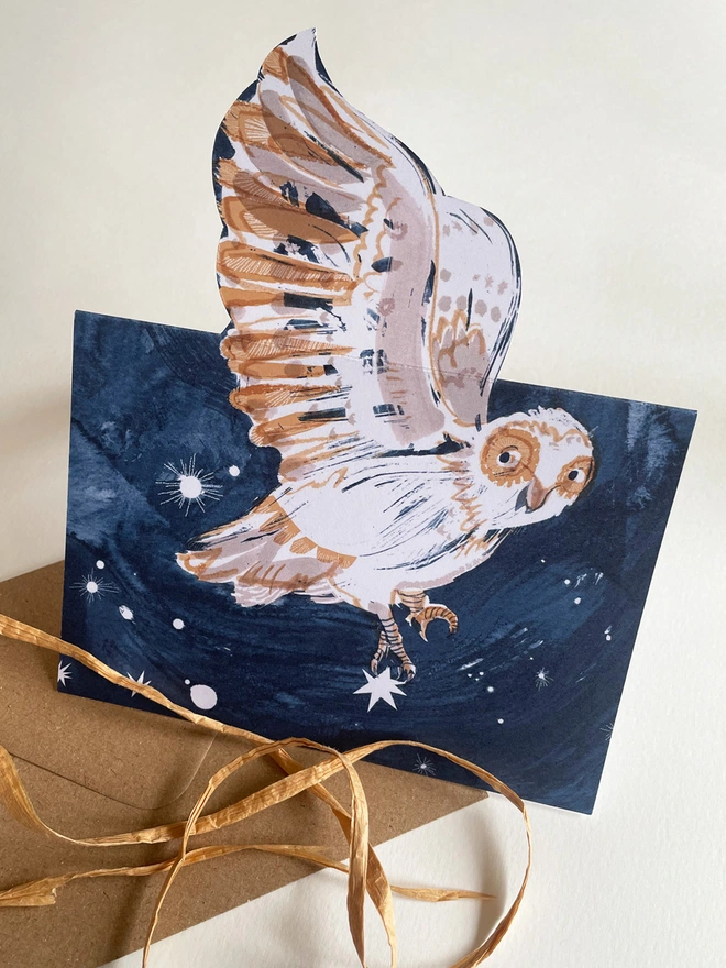 Esther Kent Night Owl illustrated greetings card shows a painterly white and brown owl on a dark blue sky. The wing folds out.