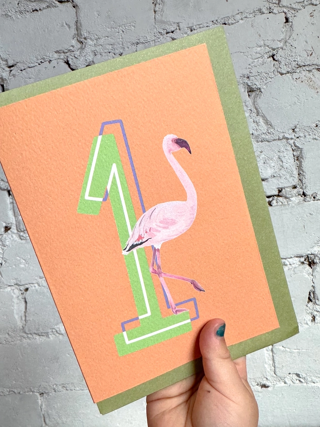 an orange card with a big green number 1 and a flamingo illustration with a green envelope