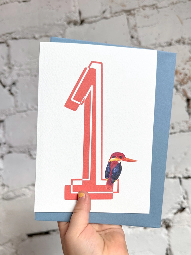 a white card with a big red number 1 and an illustration of an oriental kingfisher with a blue envelope