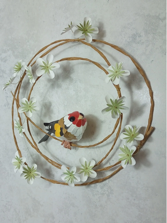 goldfinch paper sculpture on a white blossom wreath