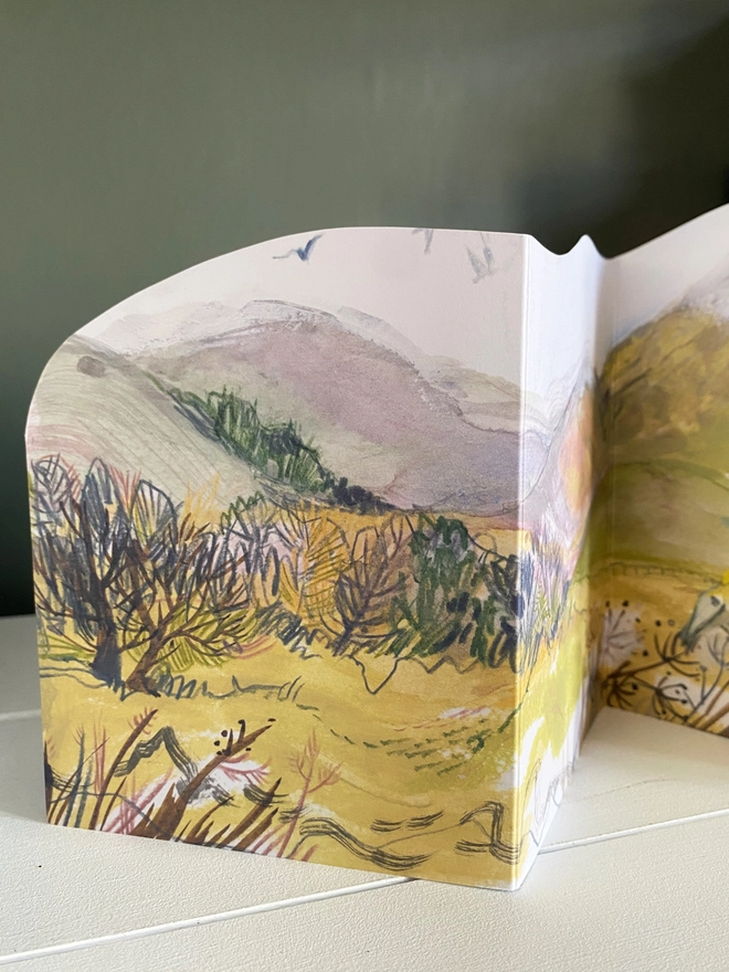 Esther kent illysrated and handcut greetings card, showing painted hilly landscape in greens and purple