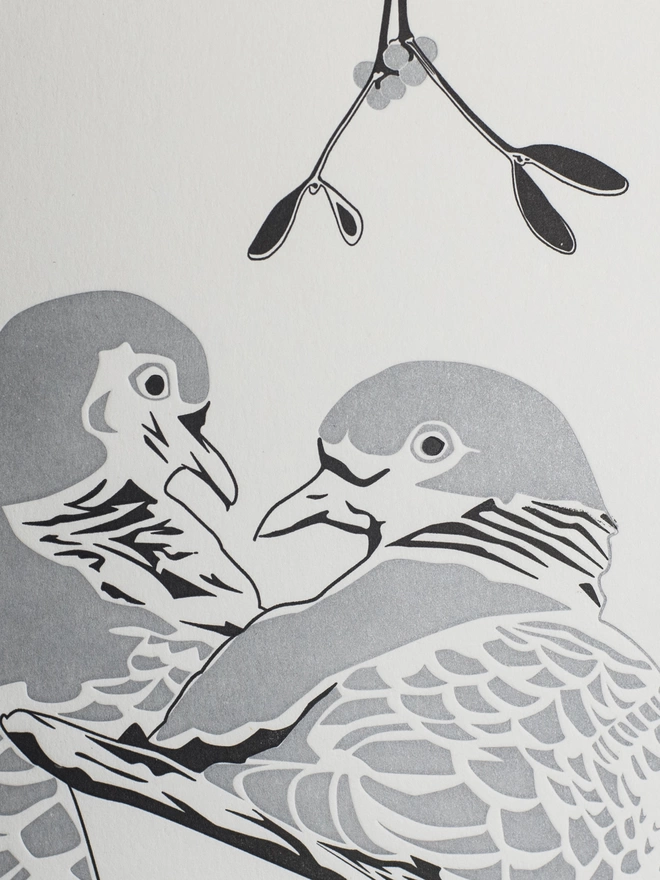 Close up of the two turtle doves looking lovinglt into each others eyes under some mistletoe