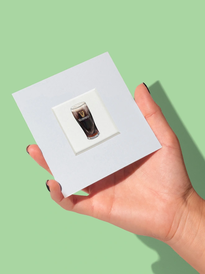 Illustrated mini print featuring a pint of Guinness showing the size f the print