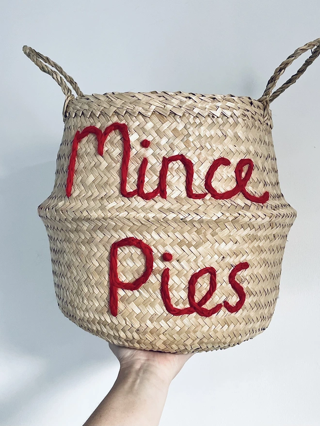 Woman holding a 'Mince Pie' Belly Basket against a plain background