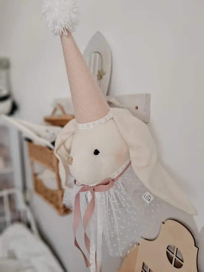 Rabbit Head Wall Mount, a cotton rabbit head wall decoration in a child's bedroom accompanied by other bedroom accessories. 
