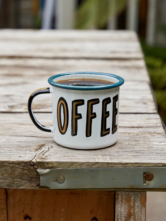 white enamel mug with 'coffee' text