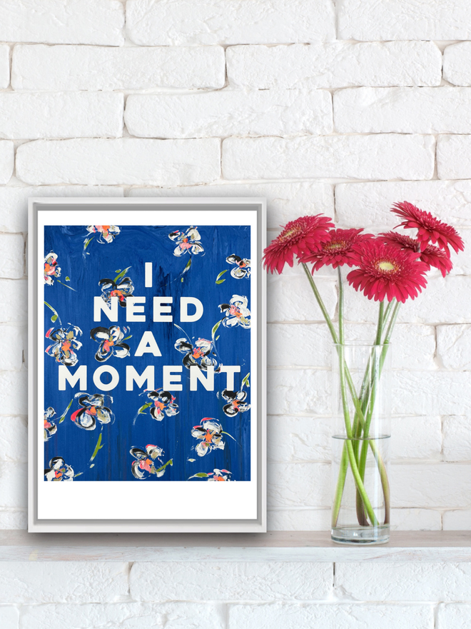 I NEED A MOMENT art print by M.E. Ster-Molnar.  Based on an original monoprint.  Shown here against a white brick wall and next to bright gerber daisies.  