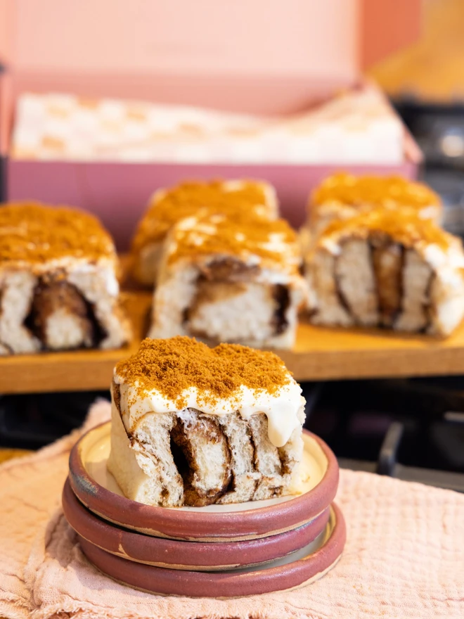 Biscoff Cheesecake Bun on a pink plate with more buns in the background