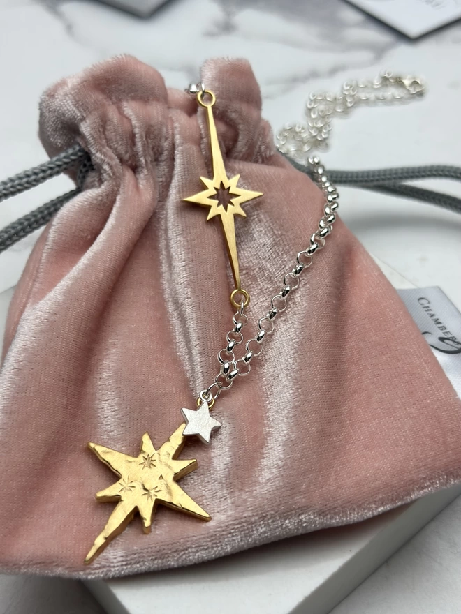 sterling silver chain with horizontal supernova star charm in gold, with a small personalised sterling silver star charm and large gold textured north star