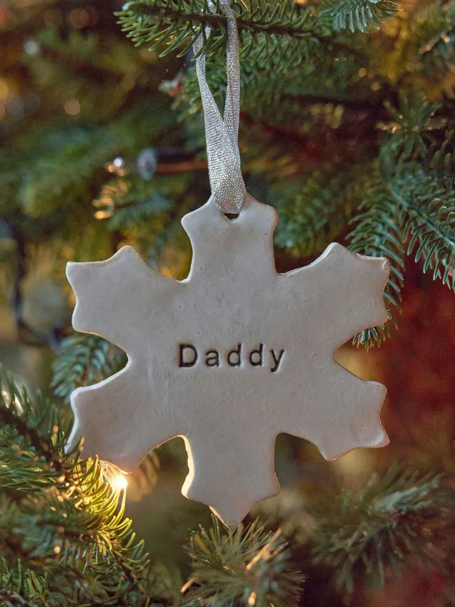 snowflake christmas tree decoration personalised in white on a christmas tree