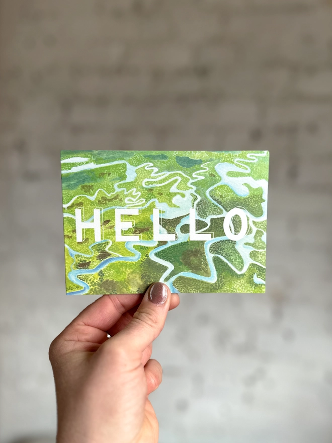 a greetings card featuring an illustration of some of the Everglades landscape with the text “hello”