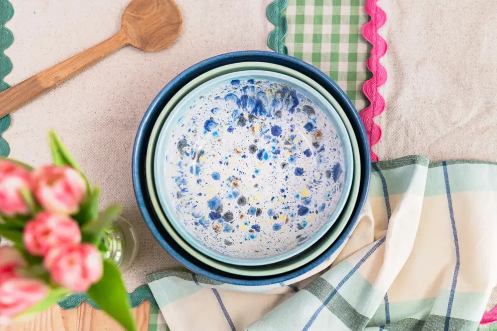 Shoreline Serving Bowls (Set Of 3), a colourful set of serving bowls placed in a table setting accompanied by other kitchen items. 