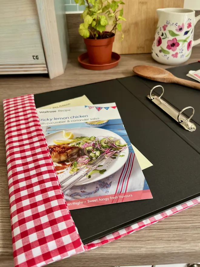 Open red gingham binder showing recipe cards & notes tucked into fabric cover overlap.