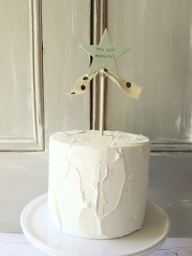 wooden star shaped cake topper with hand painted message and ribbon detail.