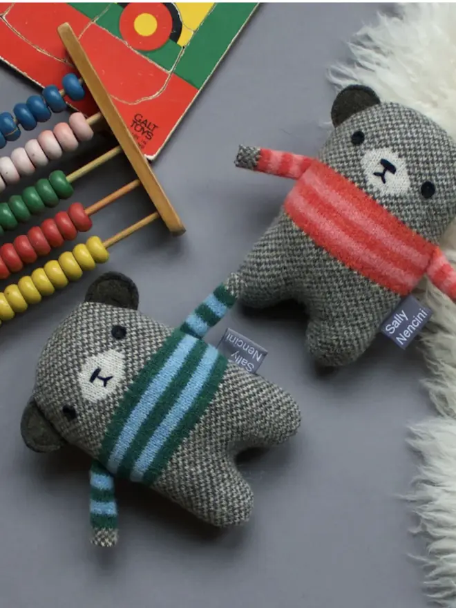 two bear plushes lying on floor with toys