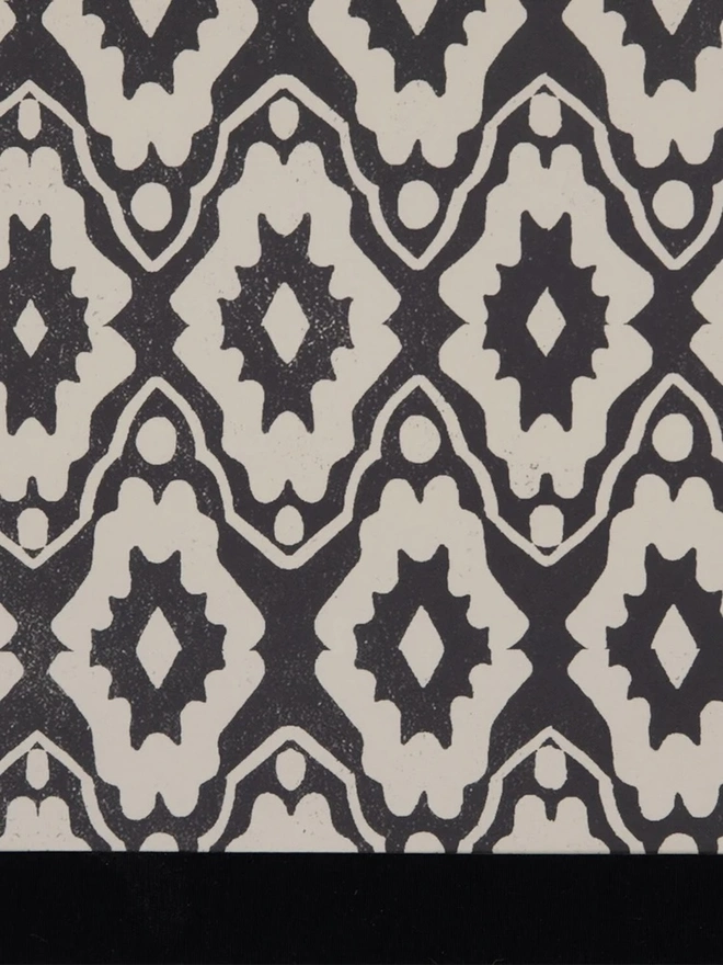 Paper Empire Lampshade. Close-up of a hand block printed lampshade showing a bold repeating geometric pattern. The colourful printed design and neat trim bring character and a handcrafted finish to any lamp.