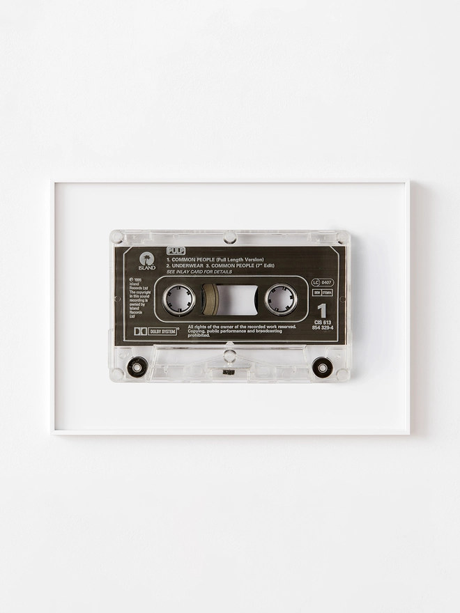 Pulp 'Common People'cassette tape print. framed print hung up on white wall.