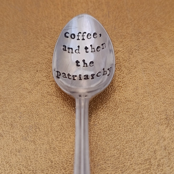 Teaspoon on gold background stamped with coffee, and then the patriarchy 