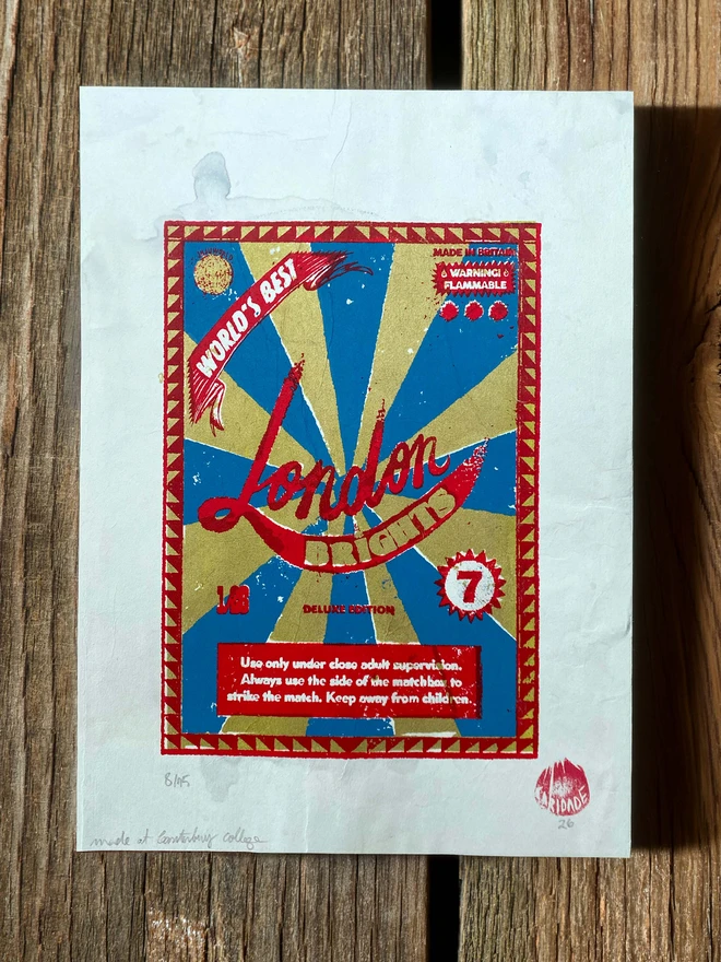 Bring a touch of nostalgic British charm to your space with this striking London Brights limited edition screen-print, inspired by the bold graphics of fireworks labels.     Featuring a vibrant palette of red, blue, and gold, the design showcases dramatic sunburst rays and retro typography, capturing the energy and character of classic mid-century advertising.      Each print includes the artist’s signature and edition number, this piece is perfect for lovers of London, vintage design, and unique statement art.