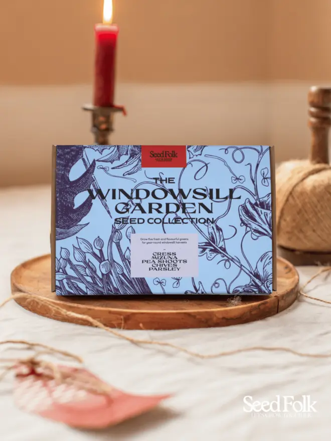 The Windowsill Garden Seed Collection. Beautiful box illustrated with light and dark blue botanical prints, photographed on a wooden tray. 