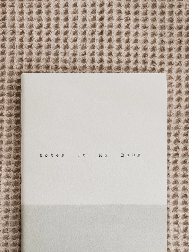 close up of text and texture on soft grey and white notebook
