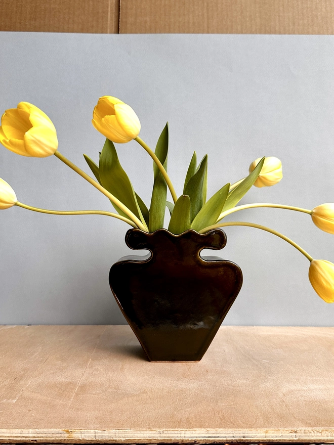 A black vase with tulips