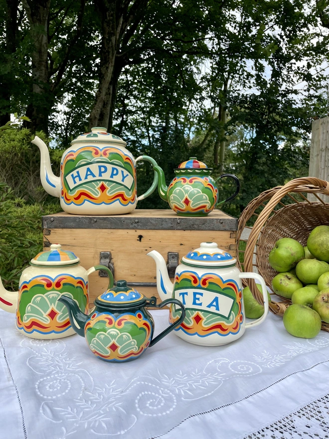 Cream teapot is pictured amongst the full enamelware collection