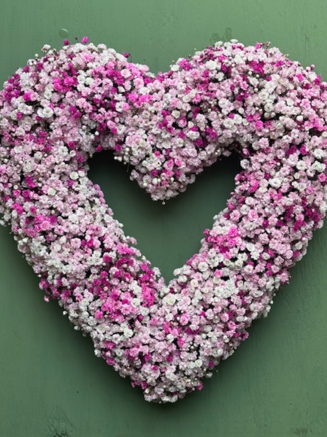 Light Pink Gypsophilia Heart Wreath against a green background