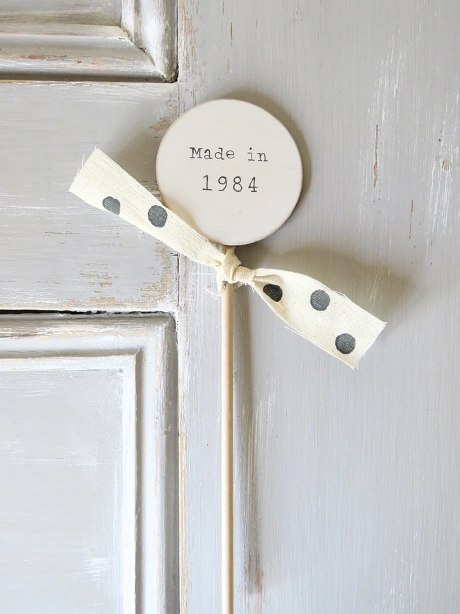 wooden circle shaped cake topper with hand painted message and custom ribbon