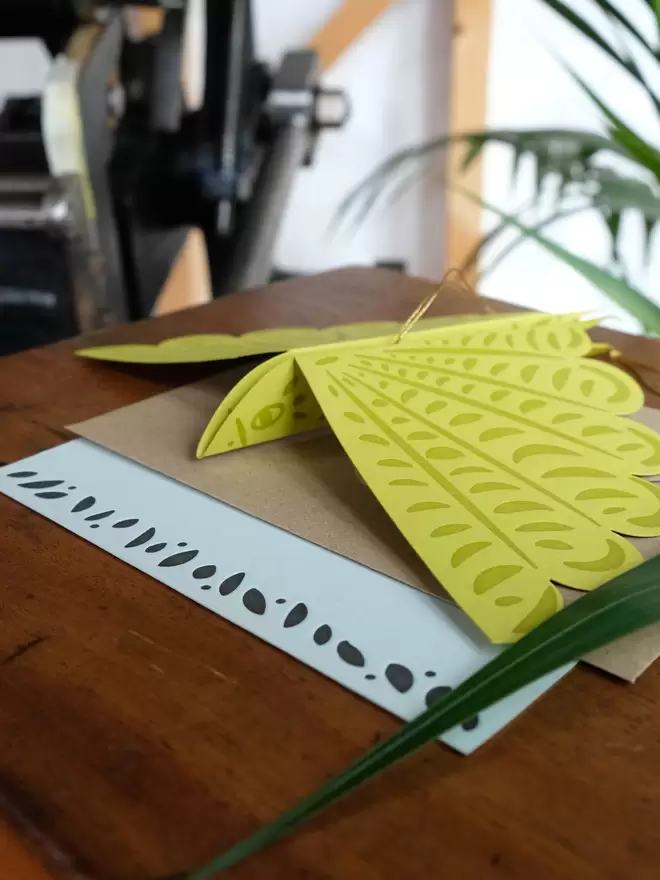 Green ink on green card hand letterpress printed bird decoration. Light green message card with small pattern across bottom.
