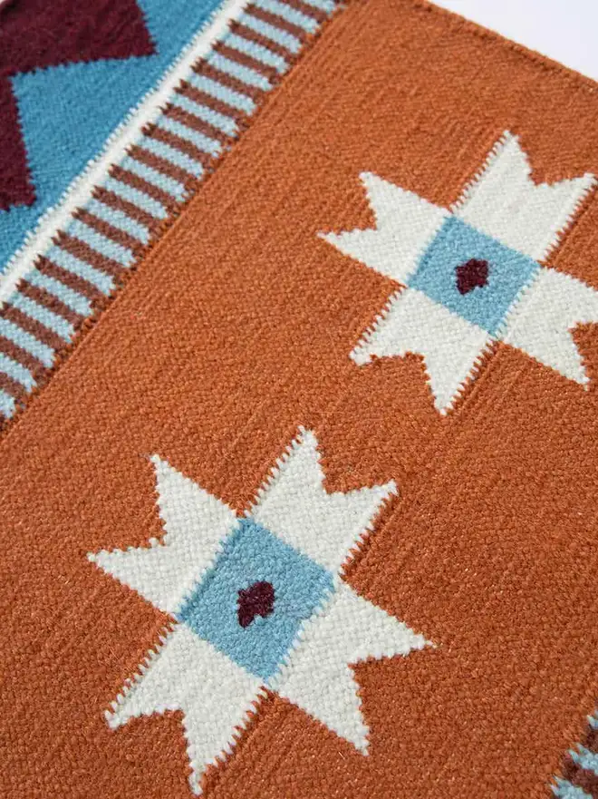 Victoria Flatweave Runner Rug, a colourful rug sitting in a decorated room. 