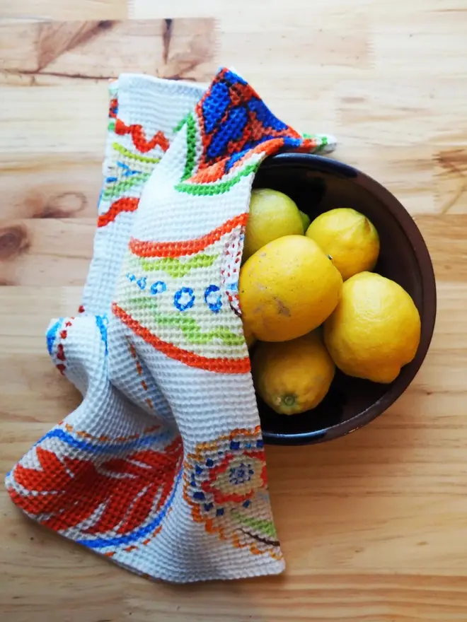Paisley Waffle Tea towel, draped over a bowl of lemons. 