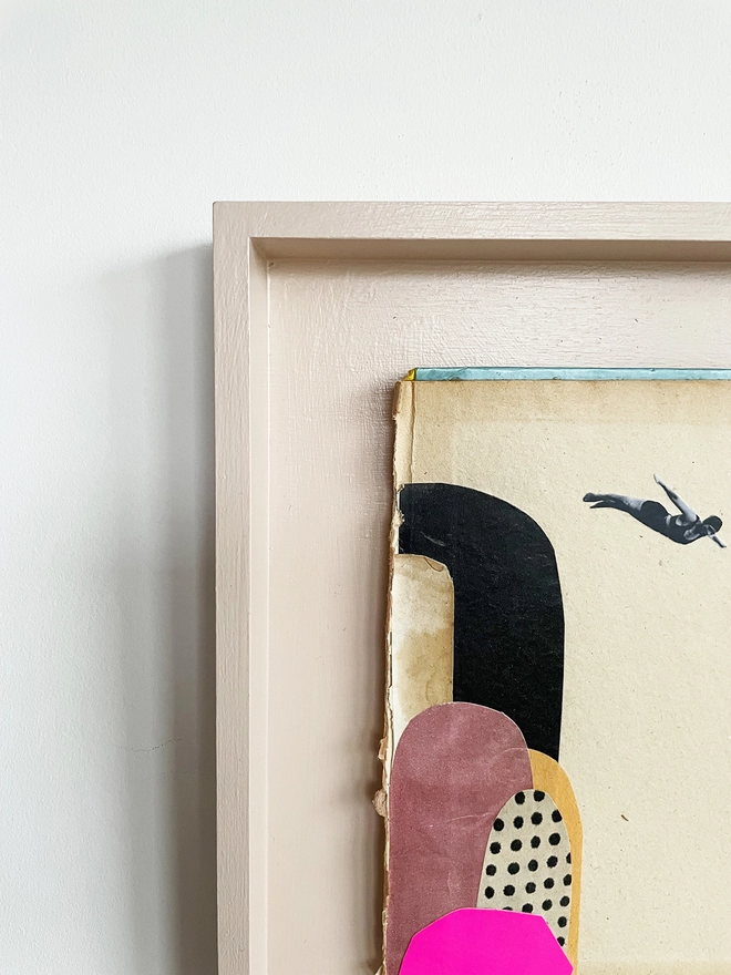 A diving portrait artwork on a vintage book cover, float mounted within a pale pink wood frame.