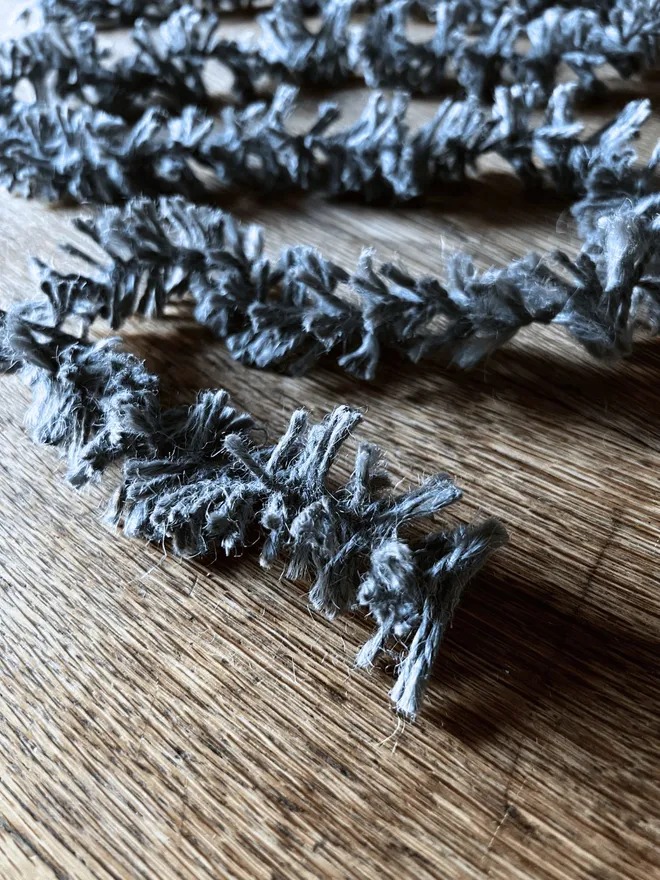 Silvery Pewter Strinsel - string eco tinsel zigzagging across on oak table top