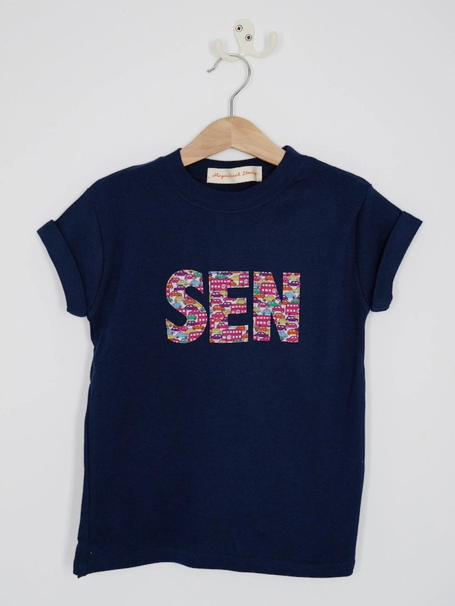  a personalised navy birthday t-shirt with a name cut from liberty cars and London buses print on the front