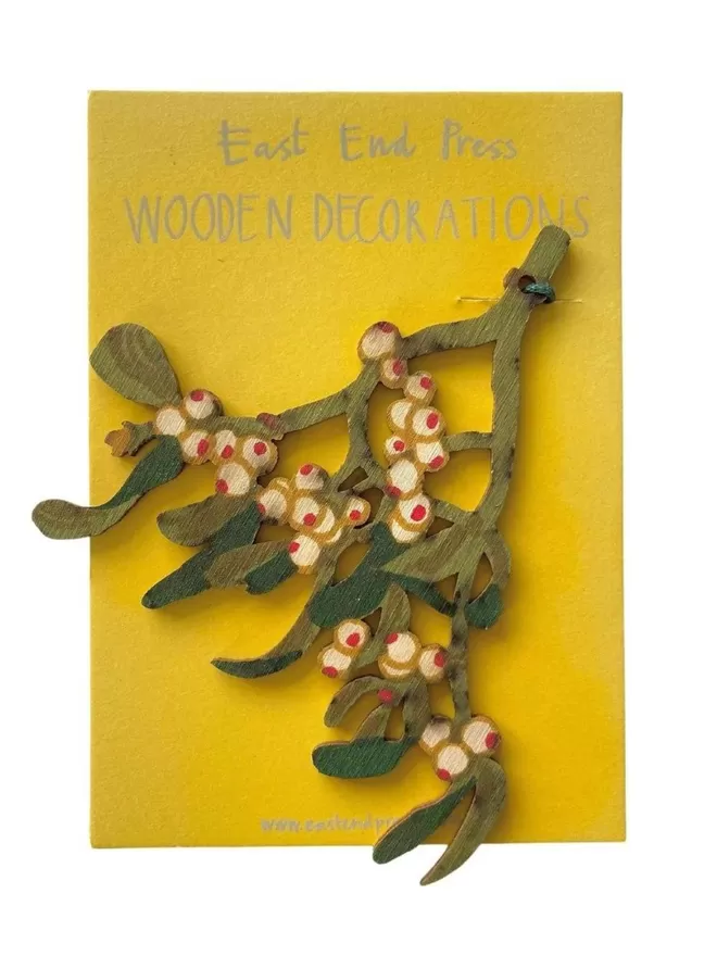 Wooden Mistletoe Decoration seen with yellow wrapping