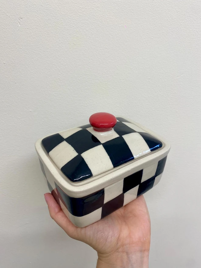  Checkered Black & Cream Handmade Ceramic Butter Dish, a black and white butter dish held against a white backdrop. 