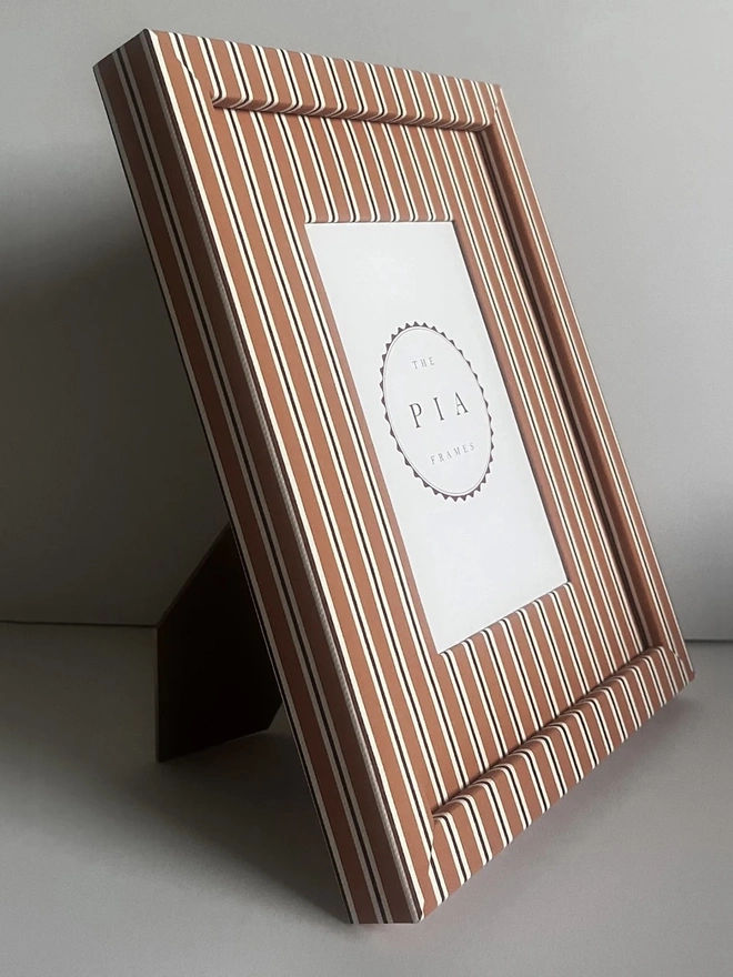 Tangerine & Burgundy Seaside Stripe Frame, a colourful striped frame sitting on a plain white surface. 