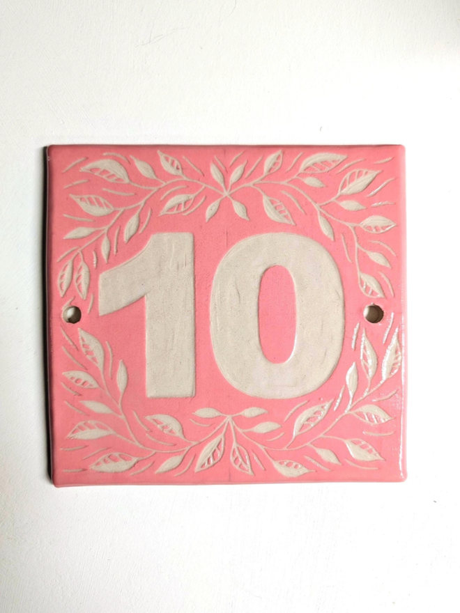 Personalised Ceramic House Number Leaf Tile. A tile in pink.