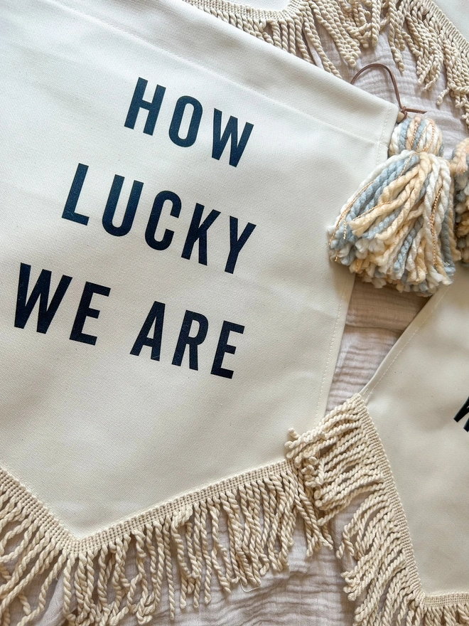 How Lucky We Are decorative wall hanging banner with tassels
